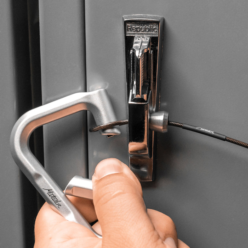 Hands placing accessory cable through locker and securing with betalock carabiner 