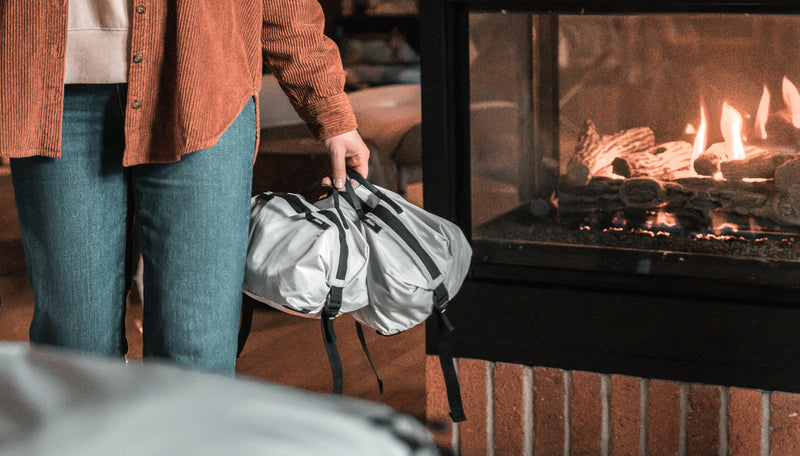 Close up view of white gear cubes being held by woman in a cozy cabin with fireplace