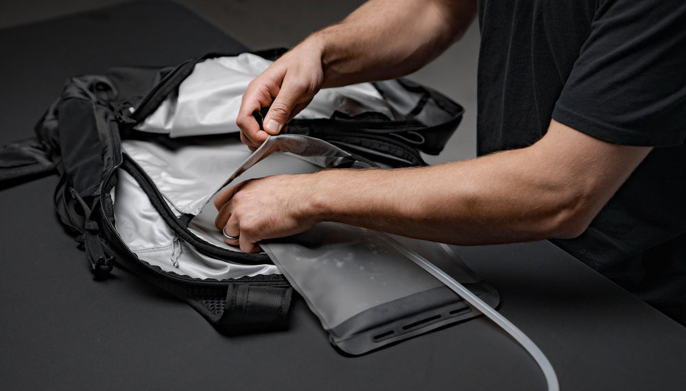 Man placing hydration bladder into beast18 backpack