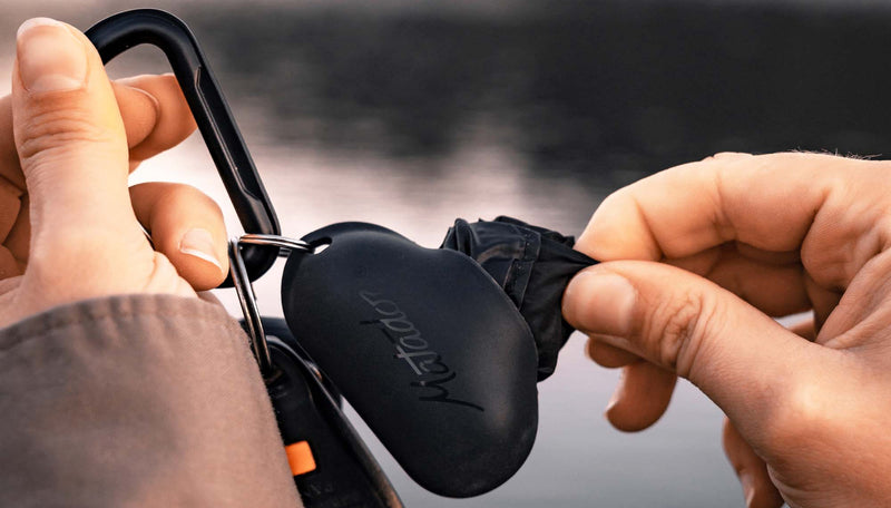 Hands pulling black Droplet out of case attached to carabiner key ring