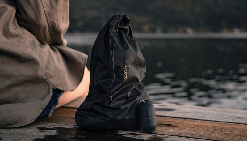 Woman sitting on dock with black Droplet and silicone case sitting next to her