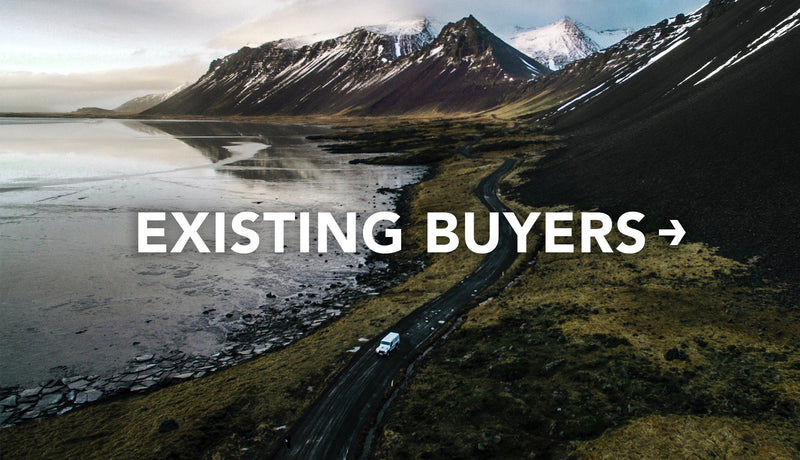 White vehicle driving down winding, dramatic mountain/lake landscape with text: Existing Buyers