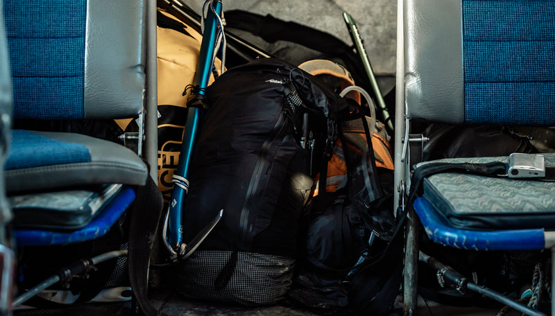 Freerain28 backpack sitting on a pile of bags in the back of a single prop plane.