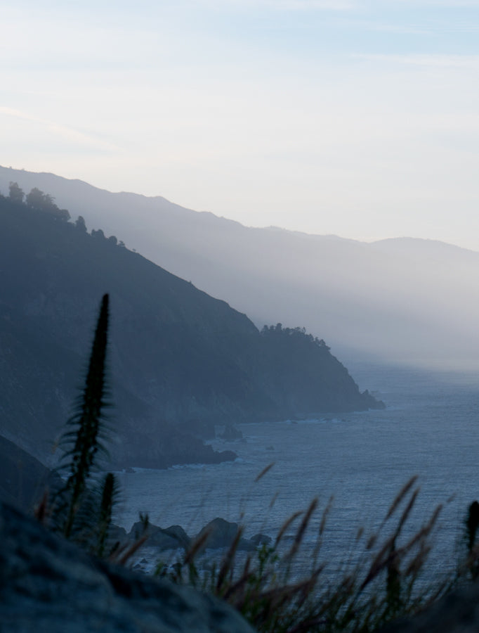 Hazy blue view of mountainous ocean coastline 