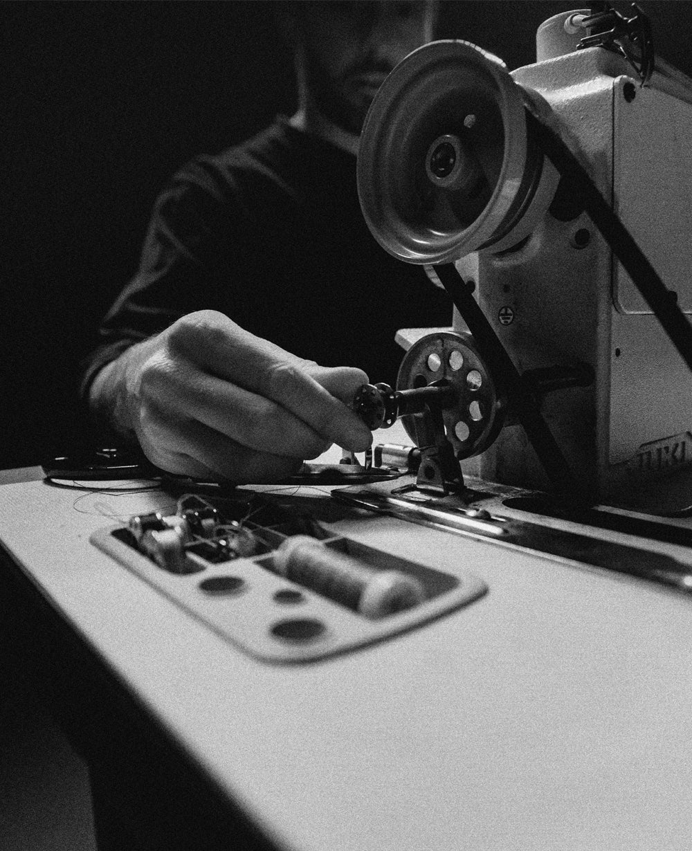 black and white image of person at sewing machine