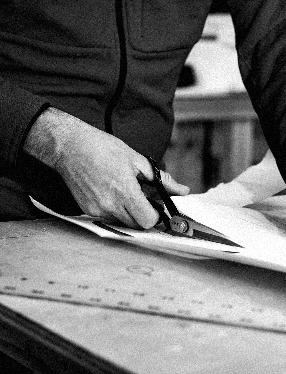 black and white image of hands cutting paper