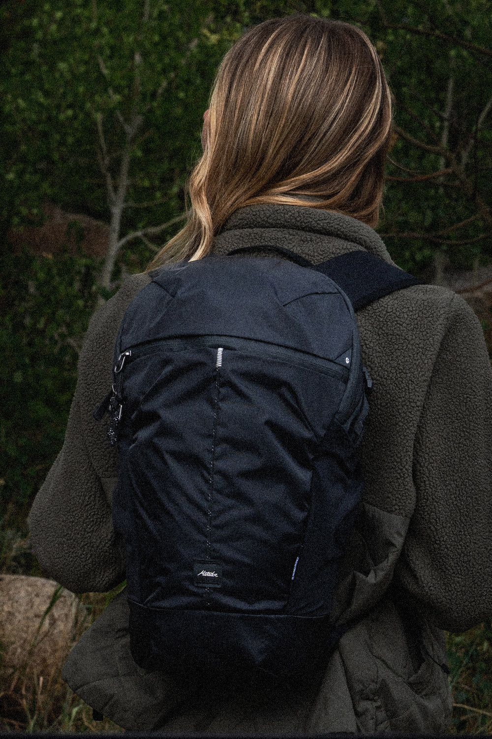 PERSON wearing black backpack outside