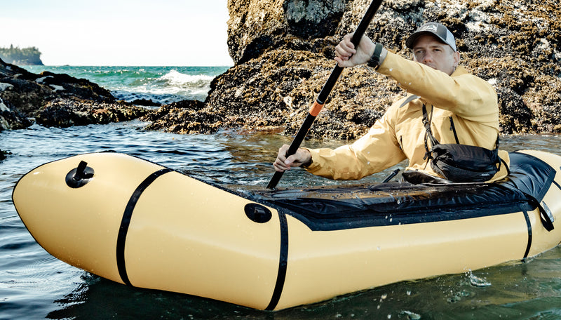 Man in yellow, inflatable kayak, wearing cross body Freerain Hip Pack