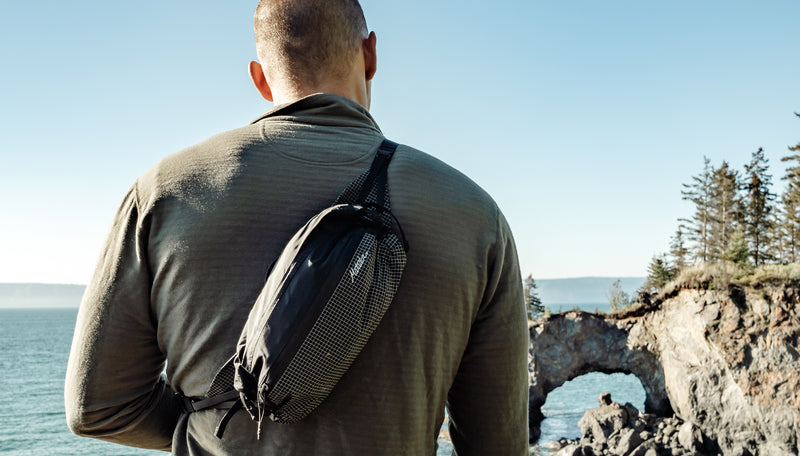 Man at shoreline, wearing Freerain Hip Pack across his back