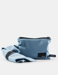 Blue pouch and towel set with a brand logo on a light gray background