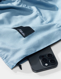 Blue towel with a brand logo and a smartphone underneath on a white background