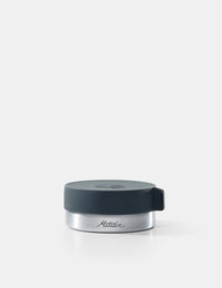 Silver container with a black lid on a white background