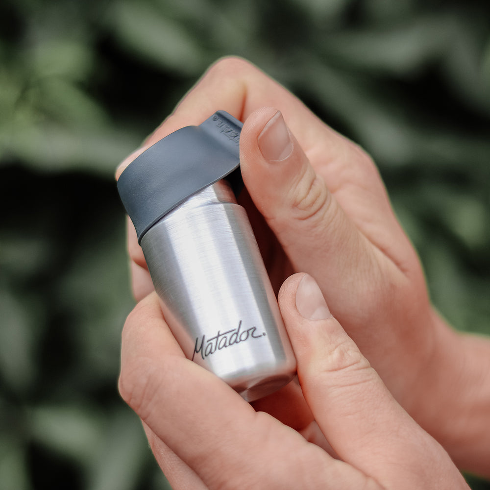 hands in front of lush background opening 40ml canister