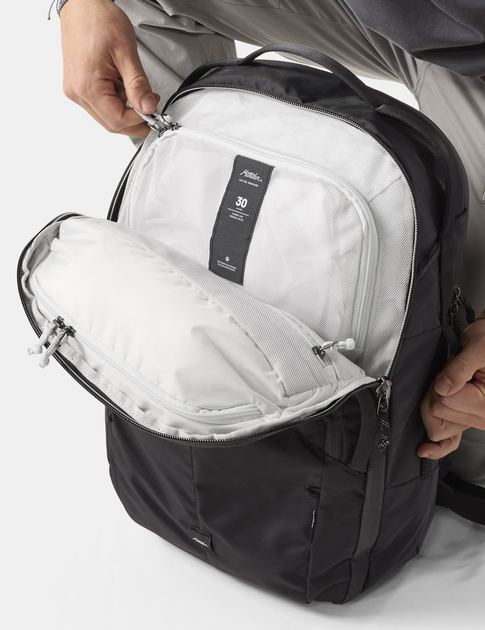 hands unzipping black backpack