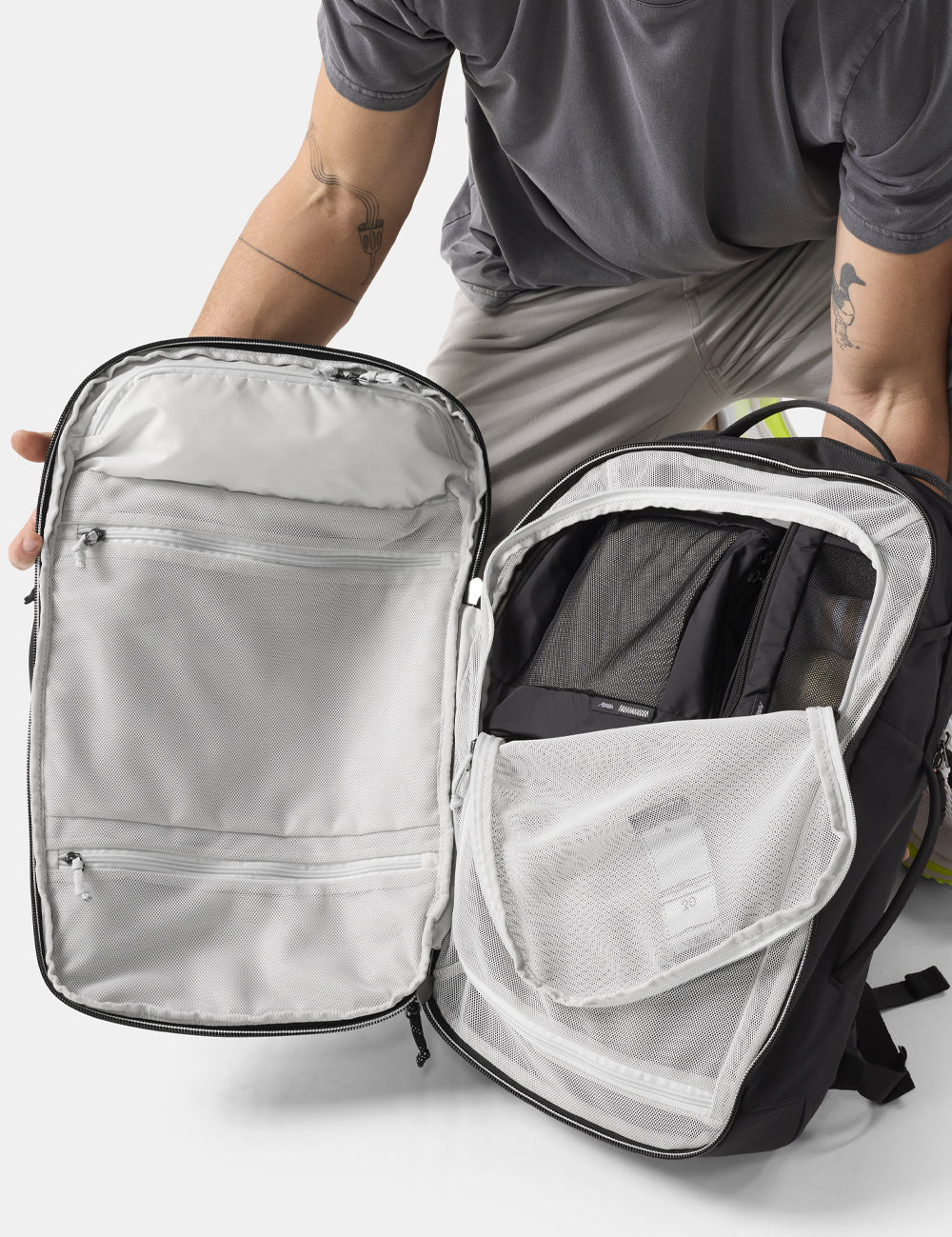 person holding open clamshell backpack
