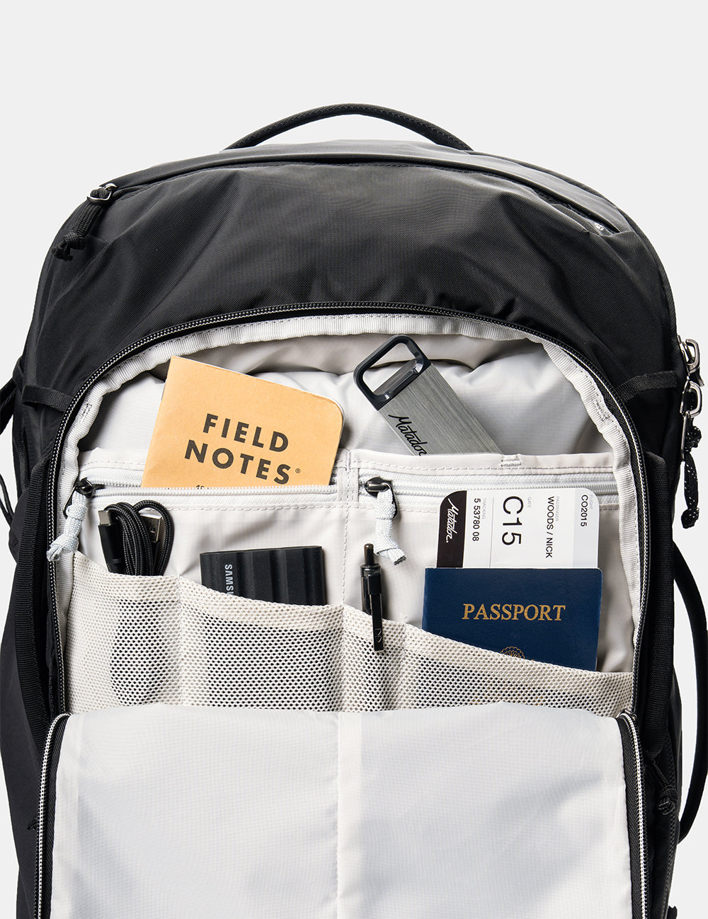 detail view of backpack pockets with cords, passport and notebook