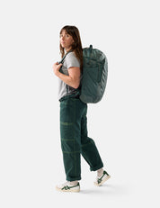 Person wearing a green backpack on a white background
