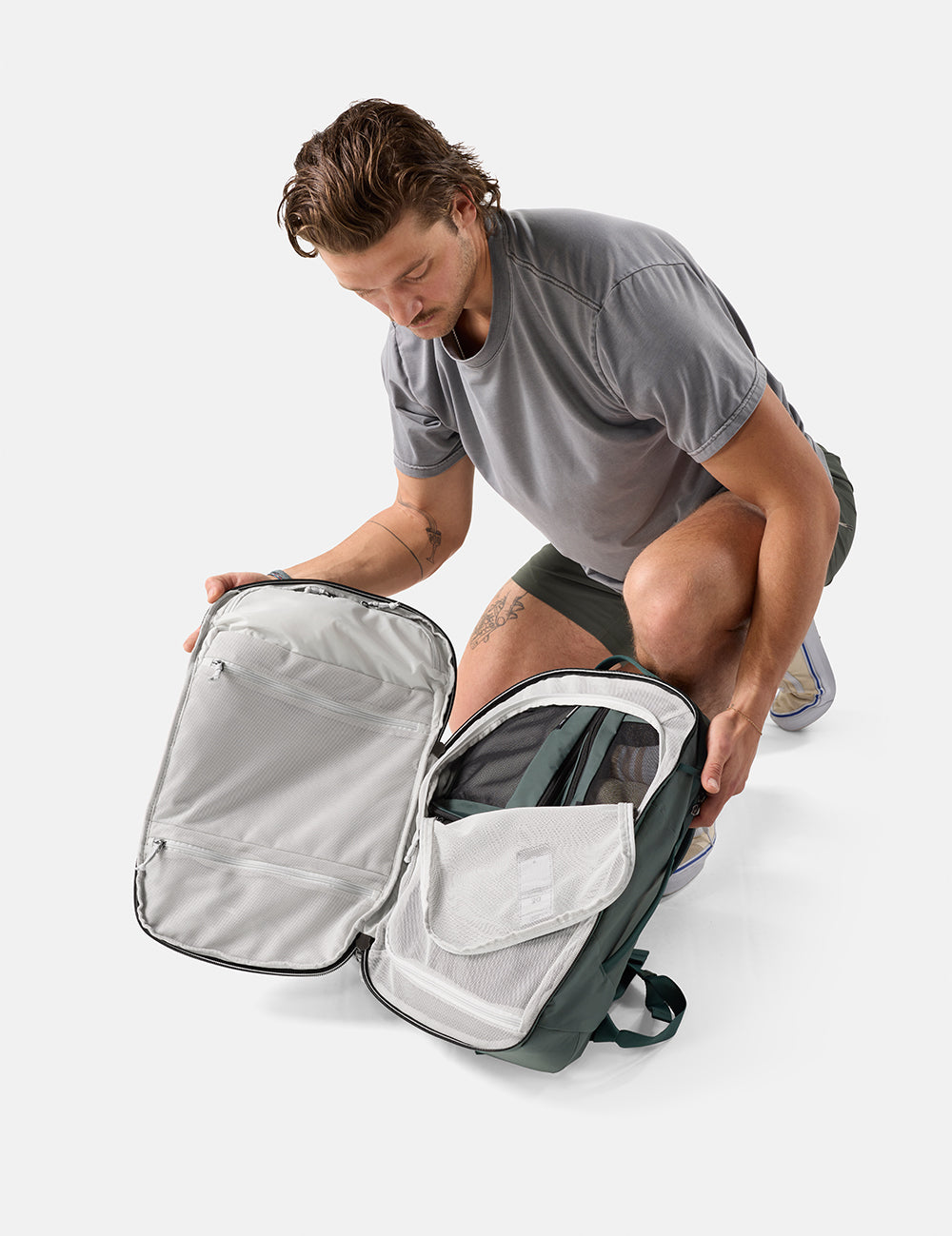 Man unpacking a juniper backpack on a white background