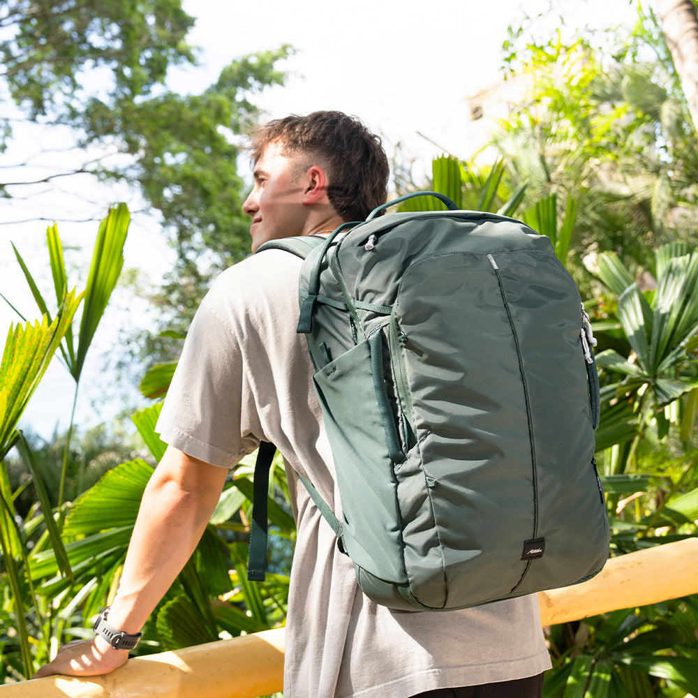 person standing on tropical balcony weaing juniper backpack