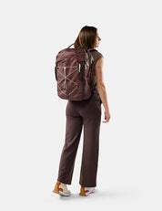 Person wearing a garnet backpack on a white background