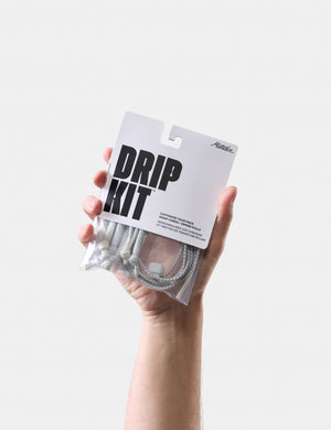 Hand holding a 'Drip Kit' packaging against a white background