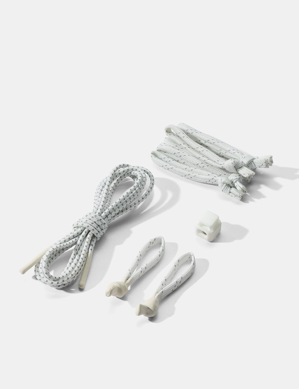 Set of white zipper pullers and tabs on a light gray background