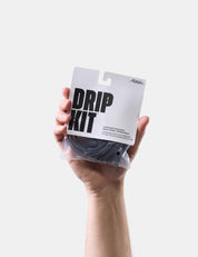Hand holding a 'DRIP KIT' package against a white background