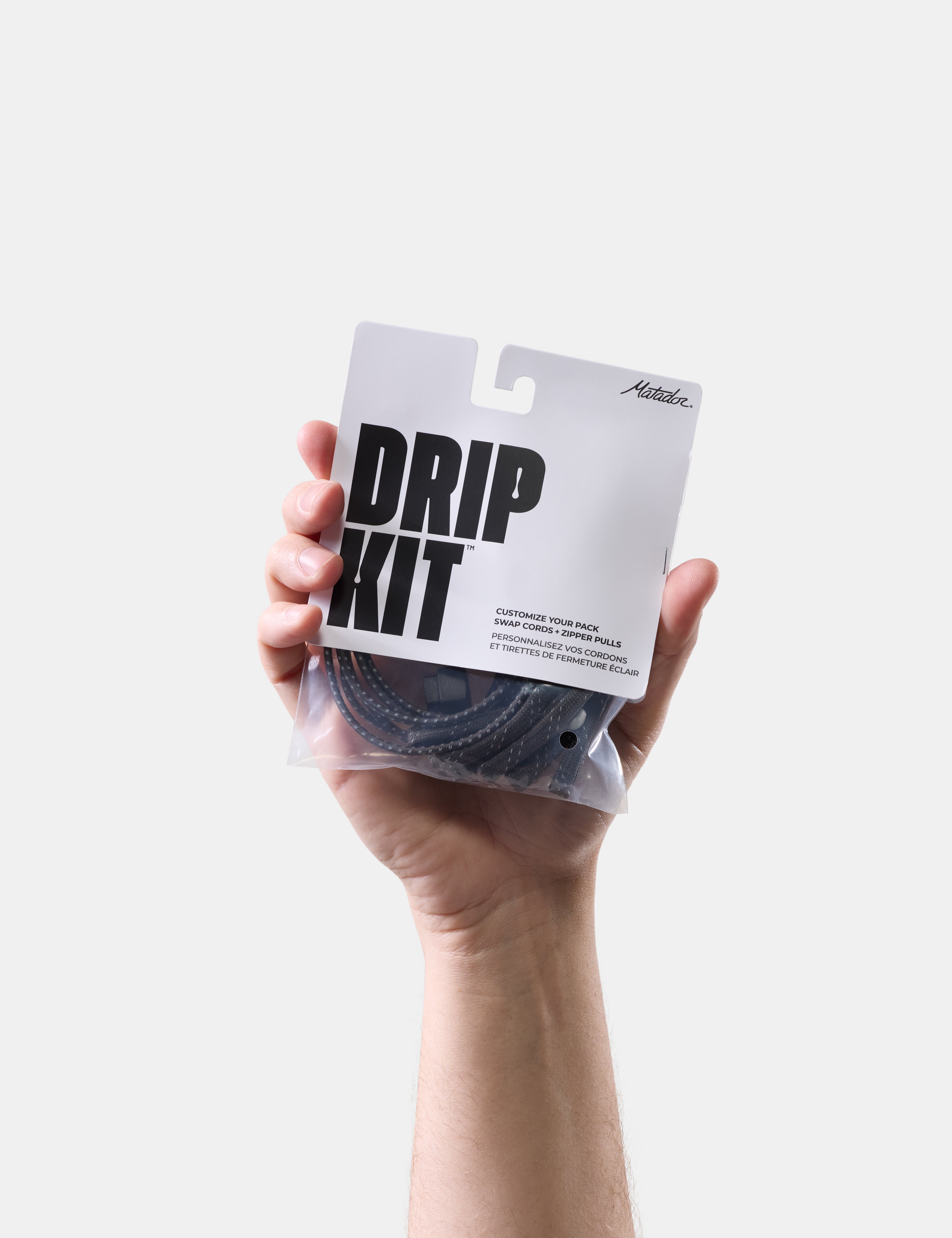 Hand holding a 'DRIP KIT' package against a white background