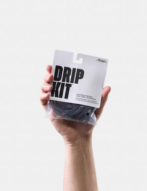 Hand holding a 'DRIP KIT' package against a white background