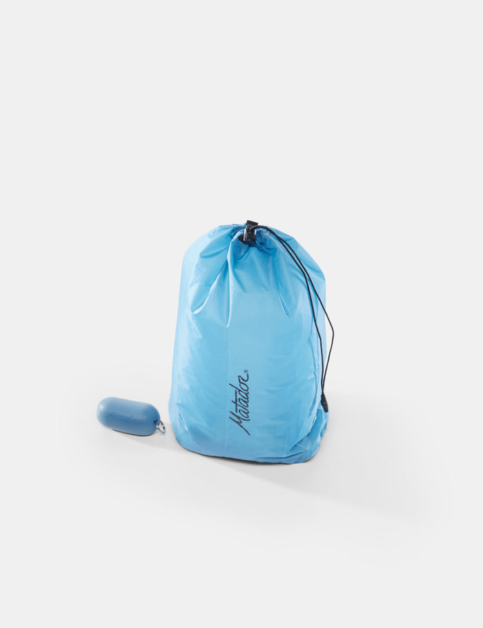 Blue drawstring bag with a small blue item on a white background