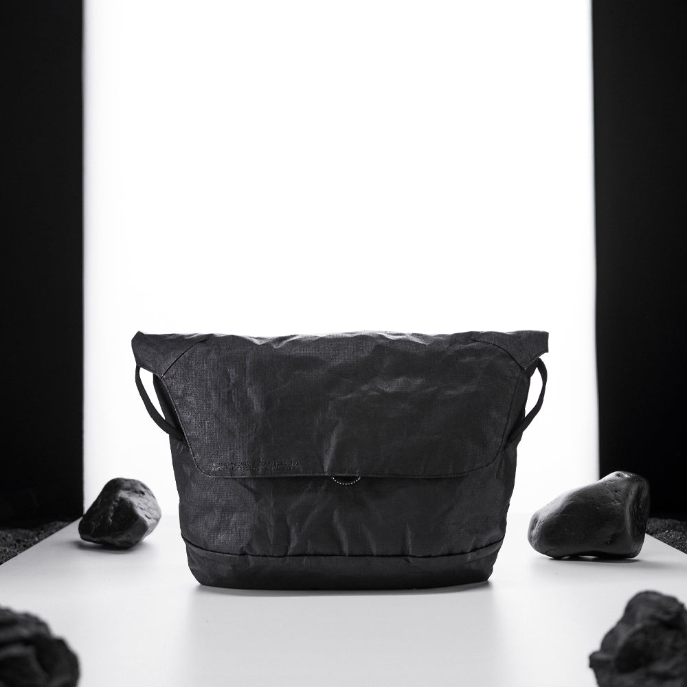 black messenger bag on light up white studio background