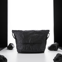 black messenger bag on light up white studio background