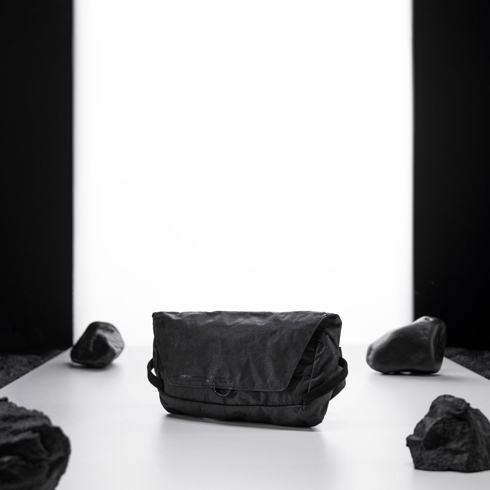 black sling bag on light up white studio background