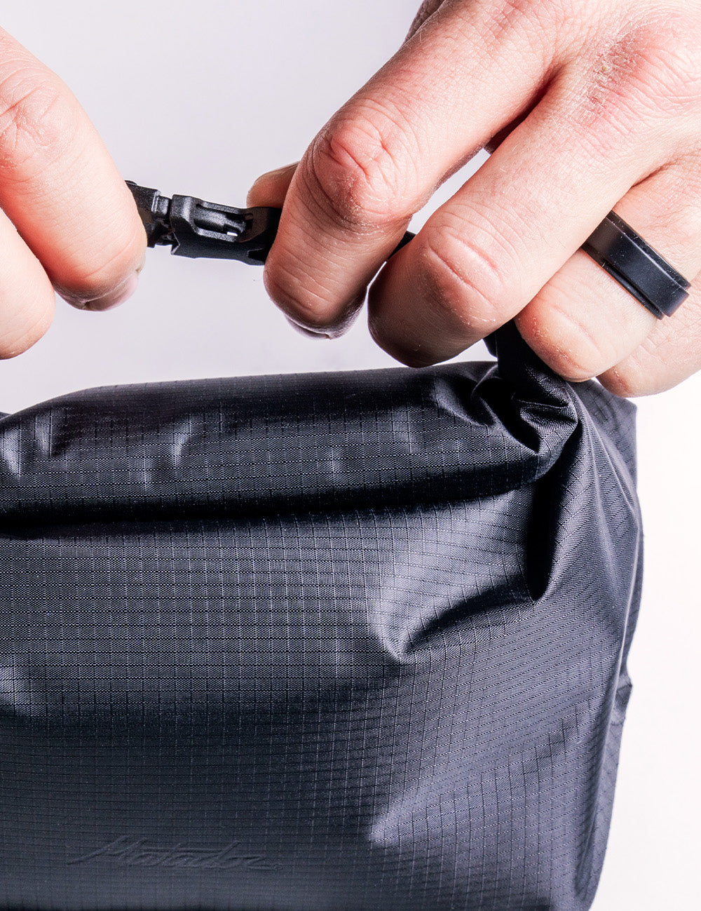 hands clipping rolltop closure