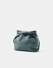 Blue-green toiletry bag with a buckle on a light gray background