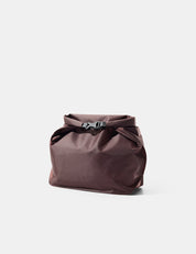 Garnet toiletry bag with a buckle on a light gray background