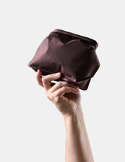 Hand holding a Garnet toiletry bag against a white background