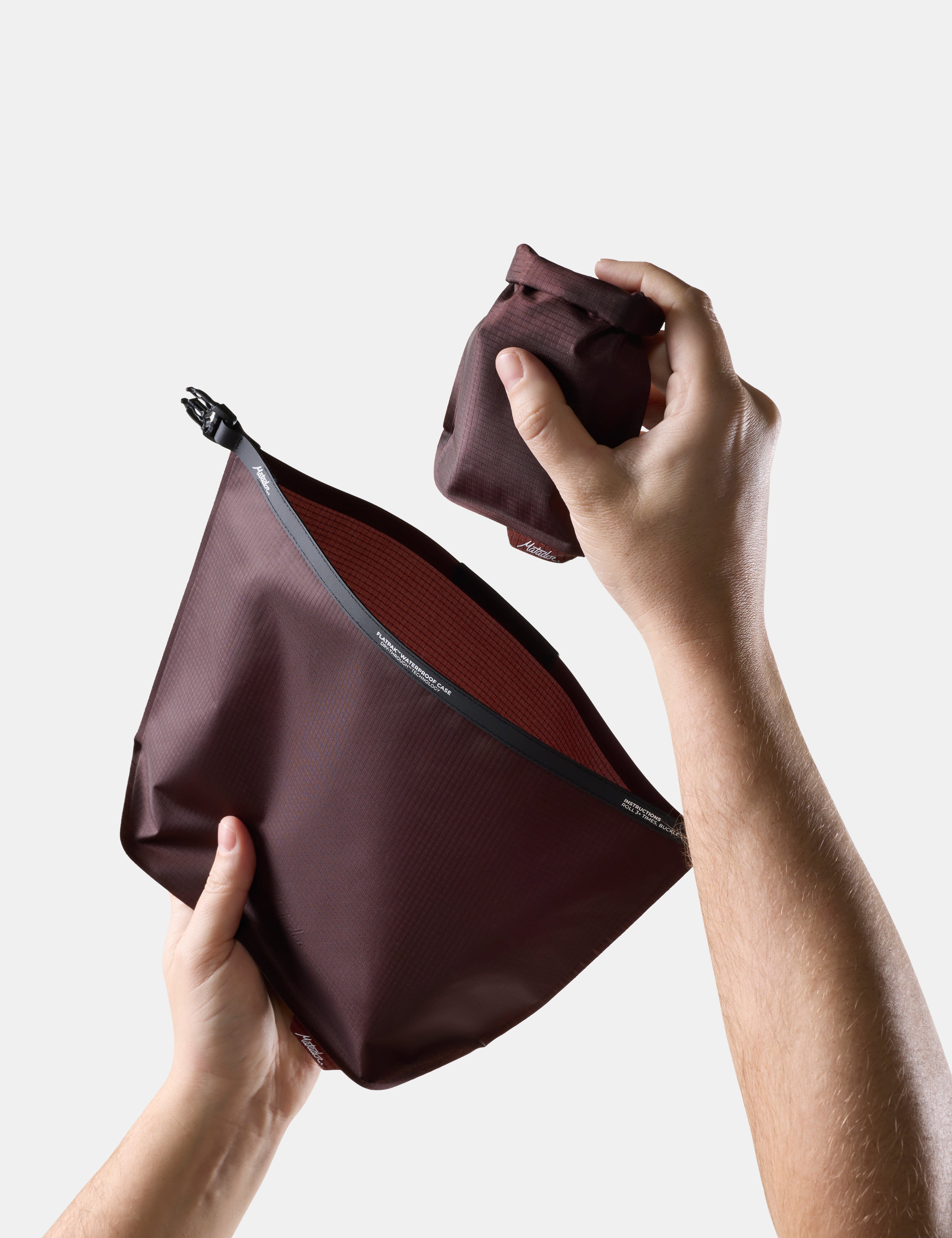 Person holding a Garnet toiletry bag and soap bar case against a white background