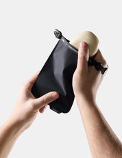 Person holding Black soap bar case with soap inside against a light background