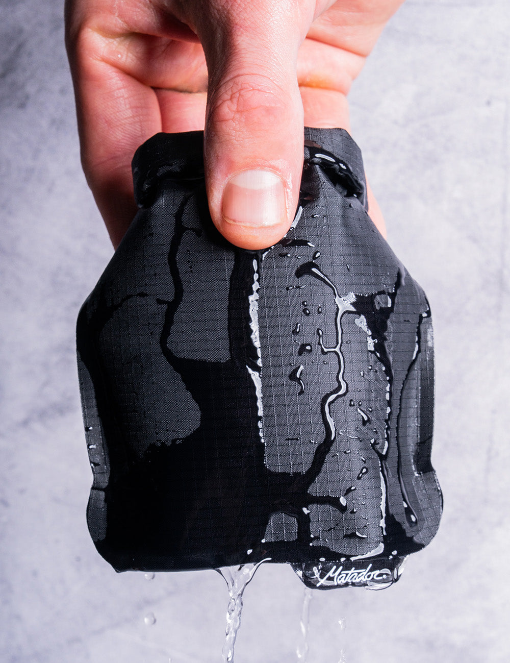 hand holding black soap bar case with water running off it