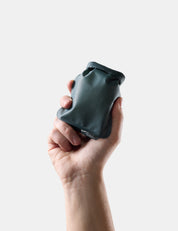 Hand holding Blue-green soap bar case against a light background