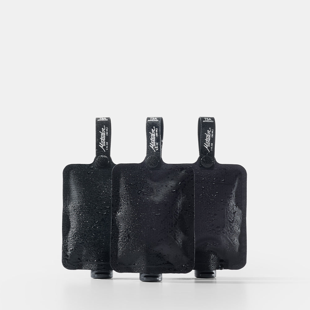 Three black toiletry bottles on a white background