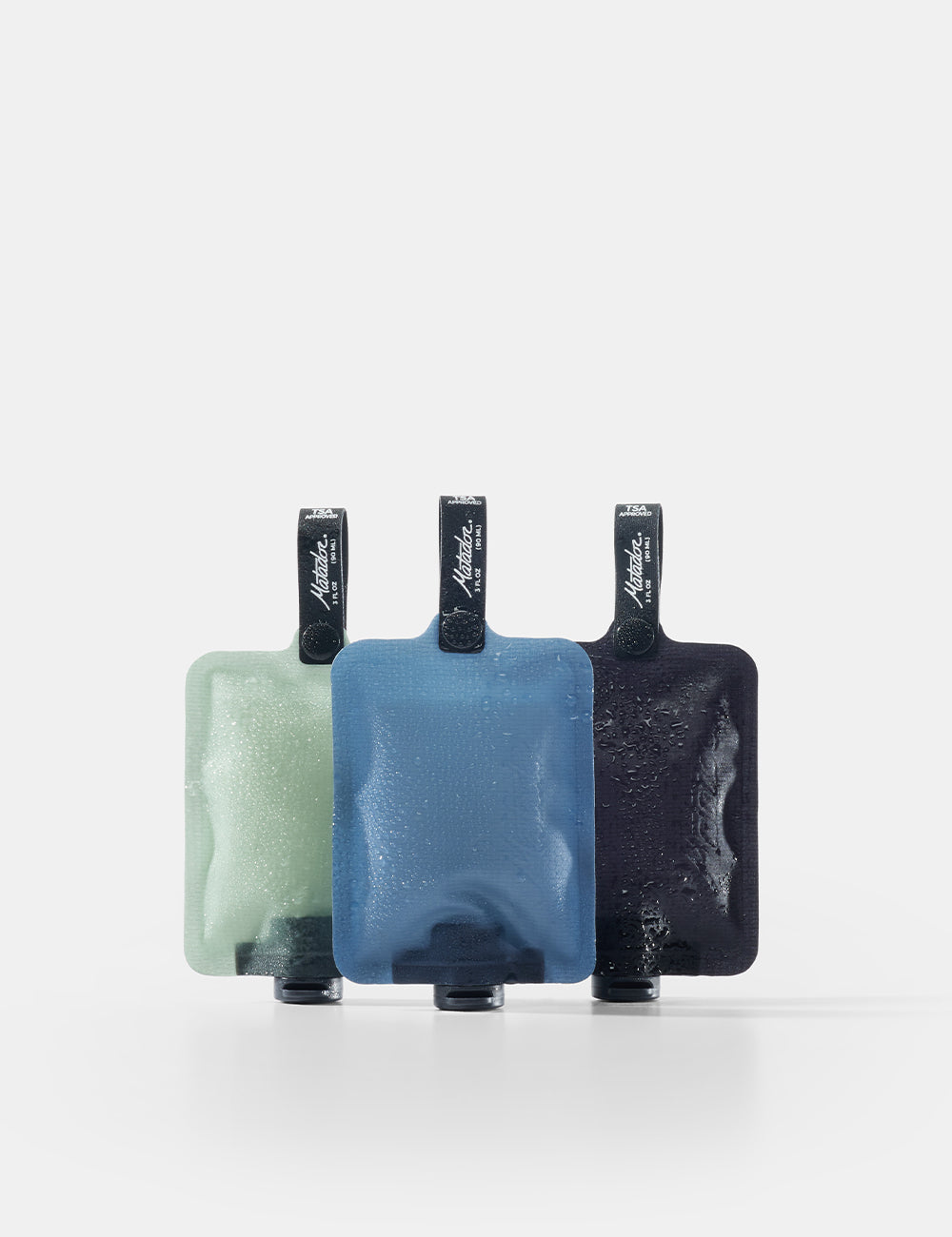 Three toiletry bottle  in green, blue, and black on a white background