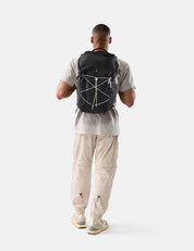 Person wearing a black backpack with a geometric design on a white background