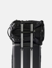 Black backpack attached to a black suitcase on a white background