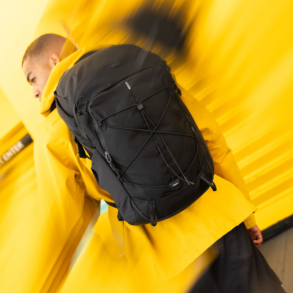 person surrounded by yellow with black backpack