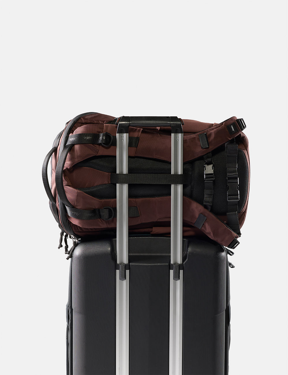 garnet backpack sitting on black suitcase
