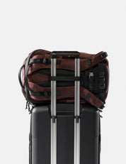 garnet backpack sitting on black suitcase