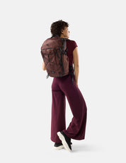 Person wearing a garnet backpack on a white background