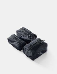 Three black travel bags with zippers on a white background